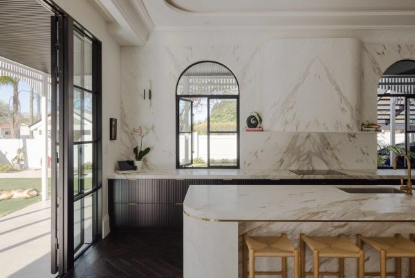 Elegant kitchen featuring a marble island and steel-frame windows, with a light colour palette and contemporary design elements.