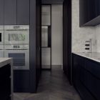 Narrow corridor in a dark-toned kitchen featuring sleek cabinetry, grey stone surfaces, and a glass partition, with herringbone flooring.