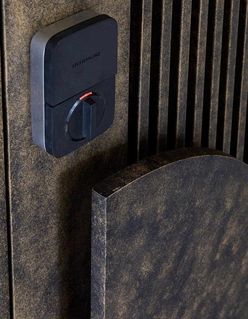 Close-up of a textured dark panel featuring a circular lock mechanism, highlighting steel craftsmanship and modern design elements.