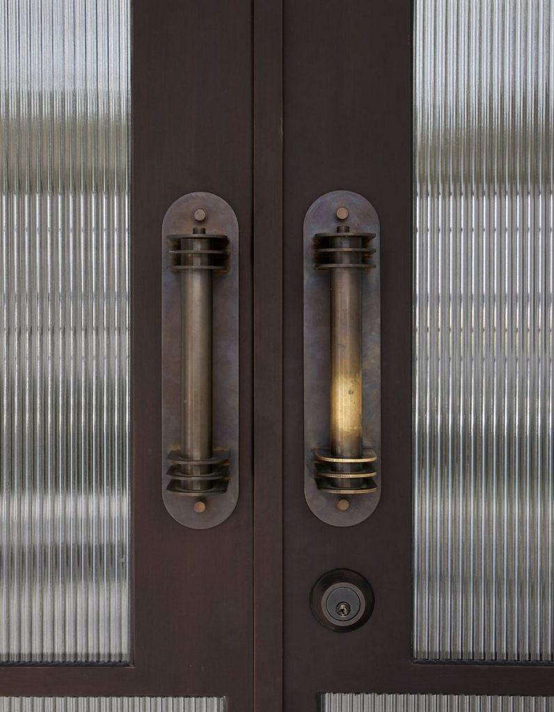 Bespoke steel double doors with textured glass panels, featuring elegant bronze handles and a contemporary design.
