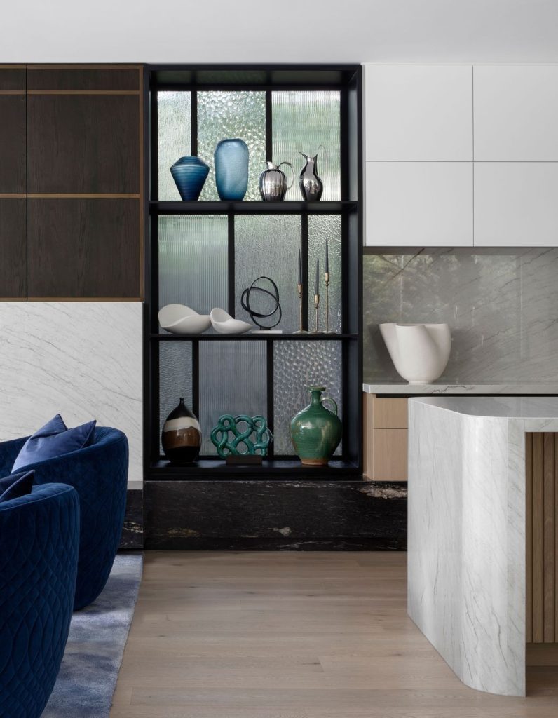 Elegant living space featuring a sleek black shelf with decorative vases, a white sculptural piece, and stylish cabinetry in muted tones.