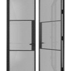 Double doors featuring a galvanised steel frame and reeded glass, elegantly open to reveal a modern design with a sleek black finish.