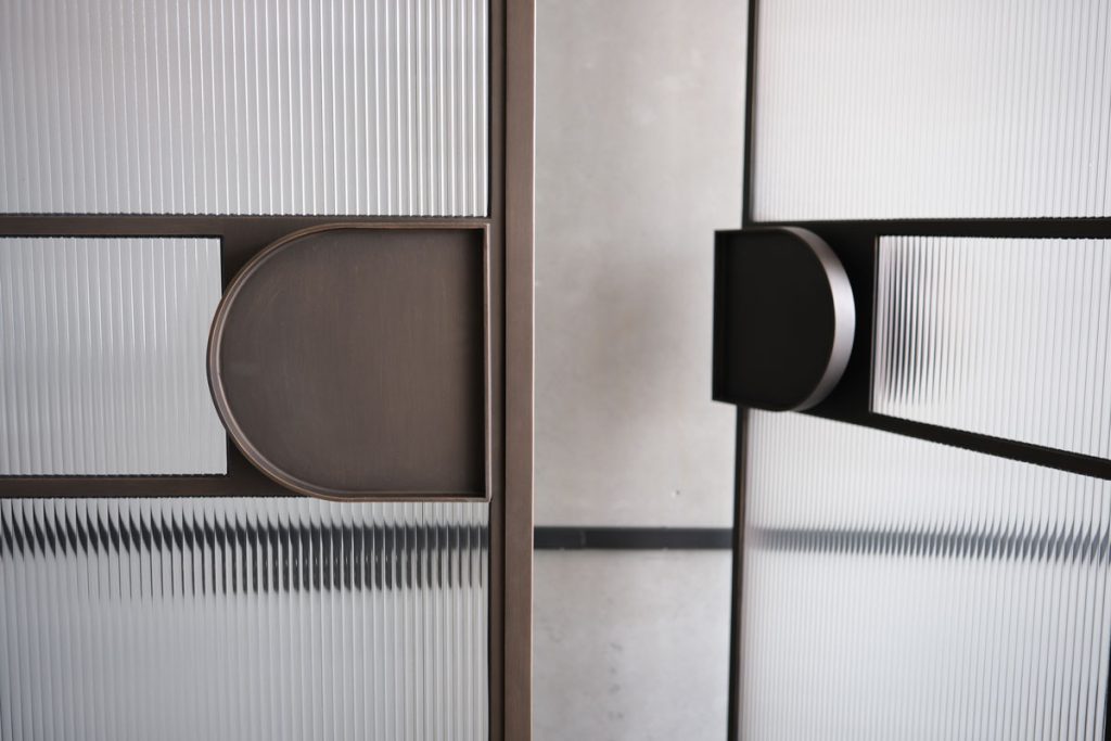 Bespoke Steel Doors with Textured Glass Panels Bespoke steel doors featuring a patterned glass design, with round and rectangular geometric elements in a bronze finish.