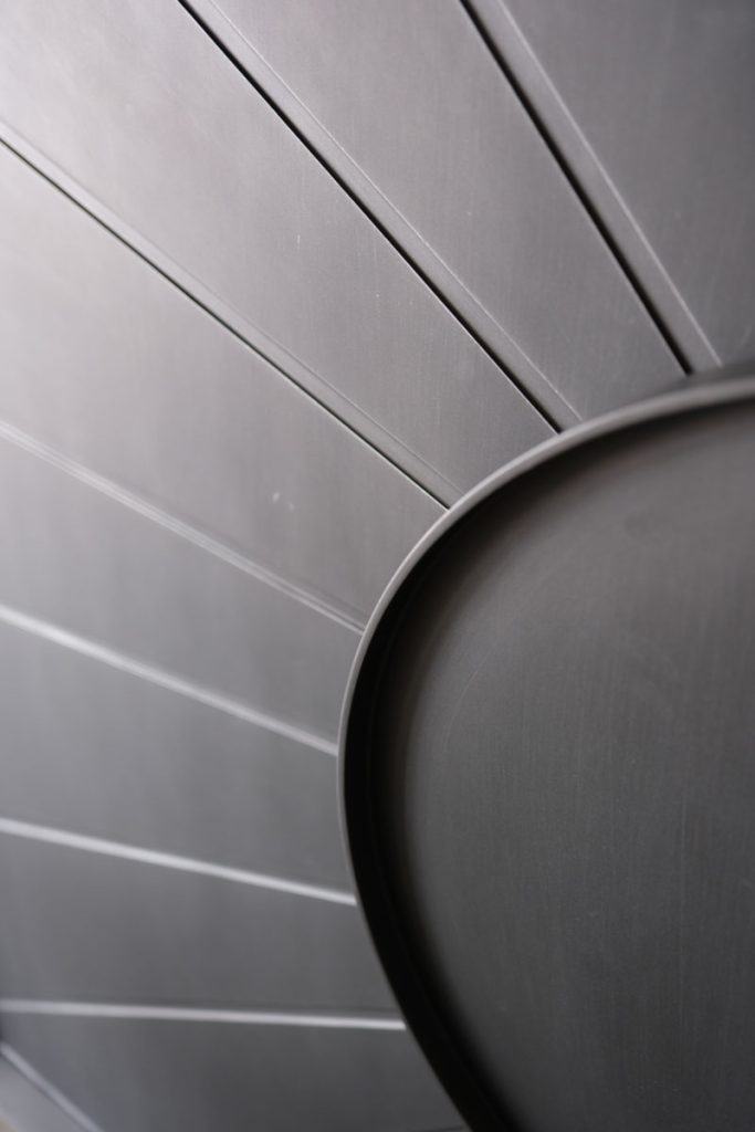 Bespoke Steel Door Design by Zen Doors & Windows Close-up of bespoke steel door showcasing precision-engineered design. Circular steel detail with sleek, grooved lines creating a modern aesthetic, emphasising precision and craftsmanship in design.