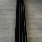 Black steel tracks on a wooden floor, designed for sliding doors, showcasing a sleek and modern architectural style.