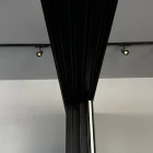 Black steel frame supports a glass sliding door, with recessed lighting above and a minimalist backdrop in muted tones.