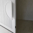Textured white entry door with a curved handle, set against a muted, light stone tile background.